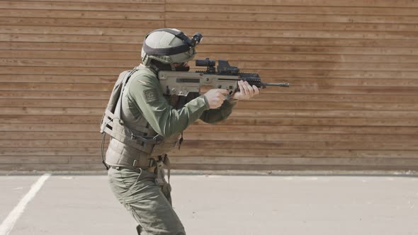 Slow motion of soldier shooting automatic rifle in a range alt