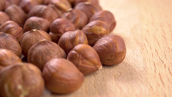 Hazelnut kernels are stacked on a wooden textured board