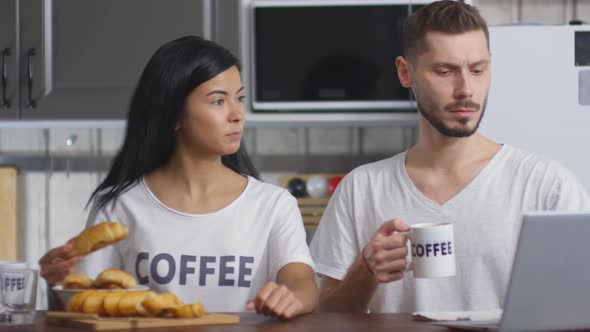 Careful Wife Giving Croissant to Husband on Breakfast