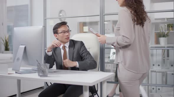 Woman Showing Papers To Boss