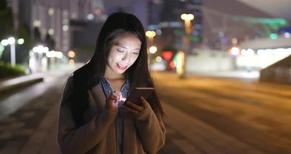 Young Woman Using Mobile Phone at Night