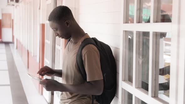 African Teenager Using Tablet Outdoor at School