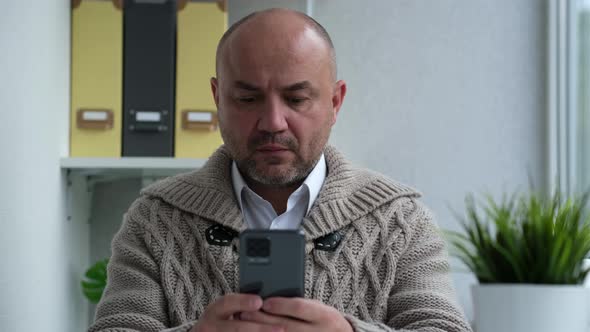 Serious Man Holding Smartphone Texting Message