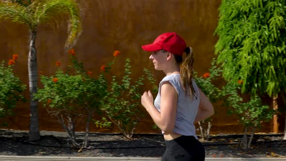 Woman Runs Down the Street Among the Palm Trees