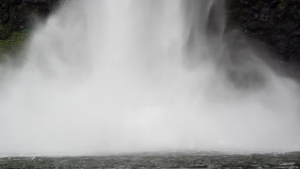 Static close up shot of a waterfall crashing down into a body of water