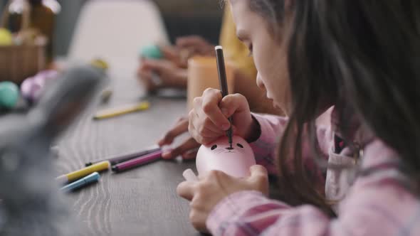 Girl Drawing Bunny Face on Pencil Cup