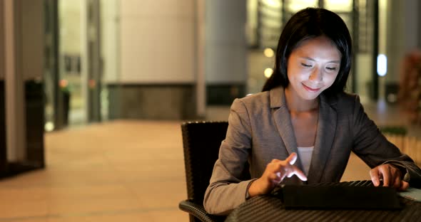 Businesswoman use of tablet computer at night 