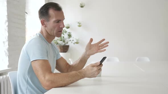 Upset Man Using Smartphone Loss