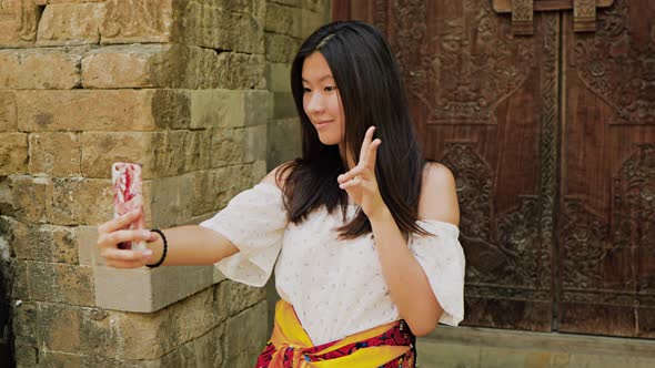 Teenage Chinese tourist explores a temple in Bali.