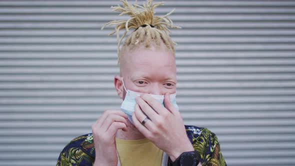 Portrait of albino african american man with dreadlocks wearing face mask