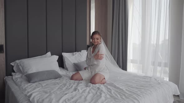 Bride Sitting on the Bed of the Hotel Room