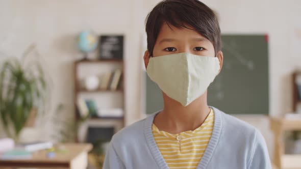 Portrait of Little Asian Schoolboy in Medical Face Mask