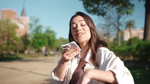 Pretty brunette woman recording voice message on mobile