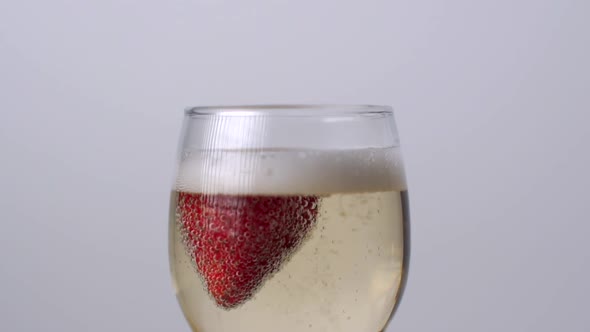 Strawberry Falling Into a Glass of Champagne on a White Background. Slow Motion 1080p