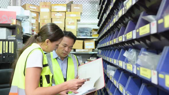 Warehouse Manager and female warehouse clerk counting the small parts stored