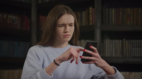 Close Up of a Caucasian Woman Browsing on Her Smart Phone While Online Shopping Looking in Doubt