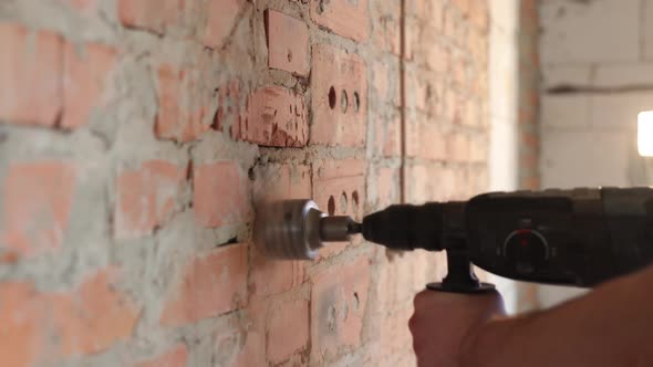 A construction worker works with a puncher close up.