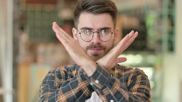 Portrait of Young Man Saying No with Hand Gesture