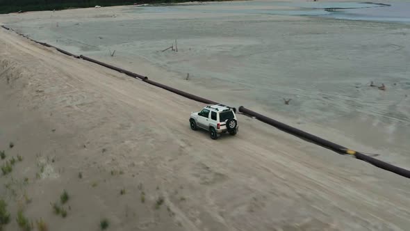 Aerial View of a Car Driving on Sand