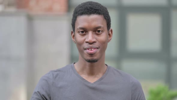 Portrait of Cheerful Young Young African Man Waving Hello