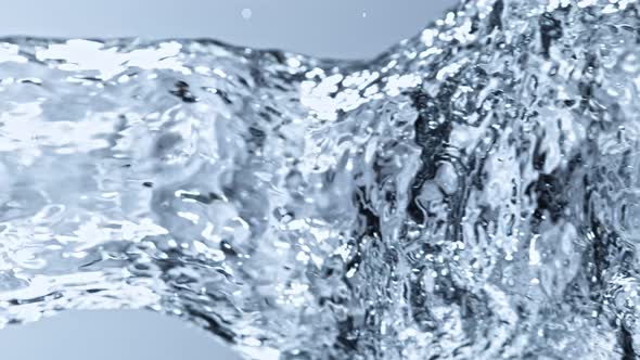 Super Slow Motion Detail Shot of Water Stream on Light Blue Background at 1000Fps