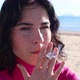 Young Woman Smokes a Cigarette on the Beach Close Up - VideoHive Item for Sale