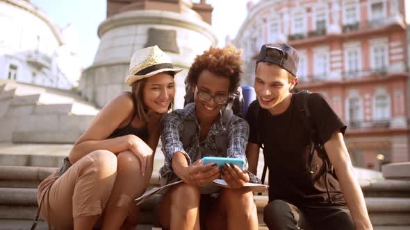 Friends Looking at Phone Smiling Sitting Outdoors Slow Motion