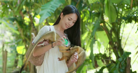 Woman feeding squirrel Monkey in park