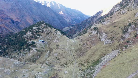 Refuge Espingo hiker shelter and Lac d'Espingo lake in Haute-Garonne, Pyrénées, France, Aerial dolly