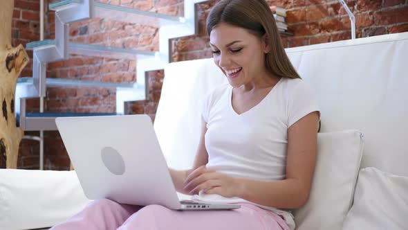 Woman Celebrating Success while Working on Laptop