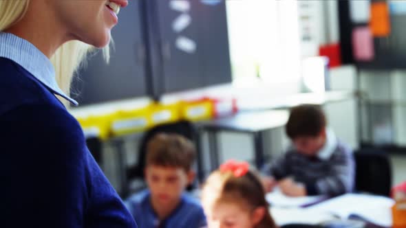 Teacher using digital tablet while teaching in classroom