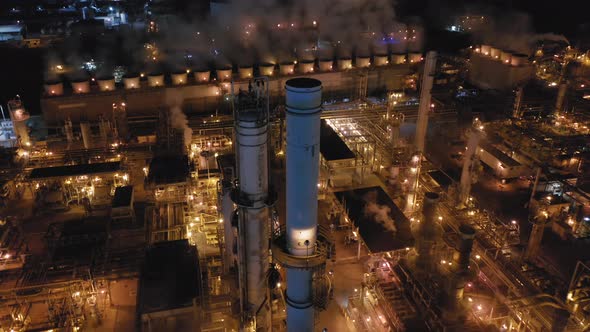 Aerial View of the Huge Petroleum Refinery at Night. Bright Industrial Illumination. Air Pollution. alt