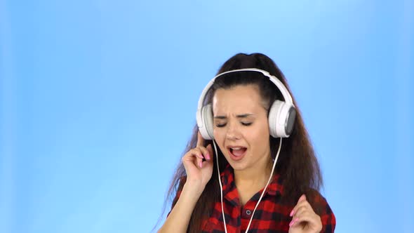 Young Lady Is Listening To Music in Headphones and Dancing