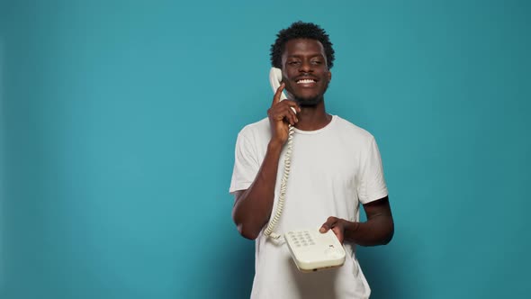 Young Adult Using Landline Telephone for Phone Call
