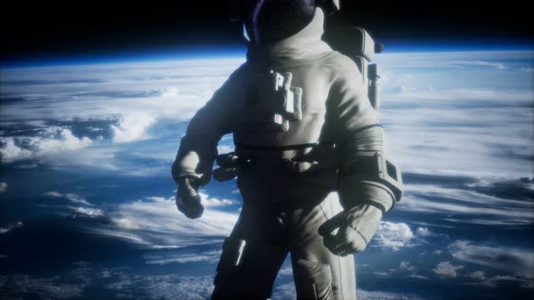 Astronaut in Outer Space Against the Backdrop of the Planet Earth alt