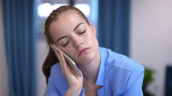 Young Bored Businesswoman Yawning Talking on Phone Indoors