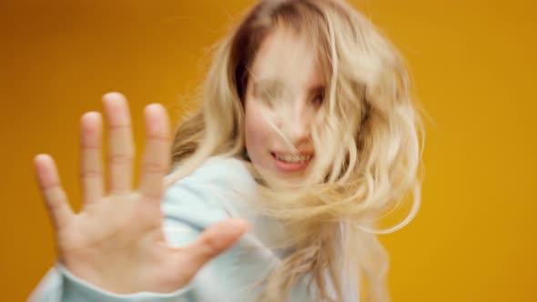 Woman Professional Dancer Dancing in Studio Against Yellow Background