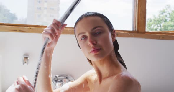Woman showering in bathtub in bathroom