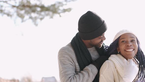 African American Couple Hugging in the Snowy Forest