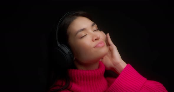 Cute Woman Enjoy Music with Wireless Headphones and Drinks From a Yellow Mug