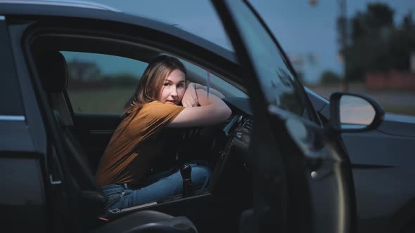 A Young Girl in the Cabin of a Car on a Summer Evening