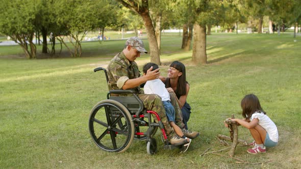 Happy Kids Enjoying Leisure Time with Handicapped Military Dad