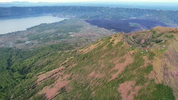 aerial pan left to right of Mount Batur volcano crater rim at sunrise in Bali Indonesia