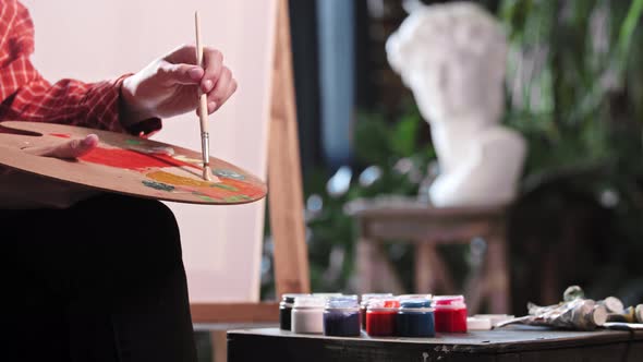 A Young Woman in Art Workshop Mixing a Beige Color on the Palette