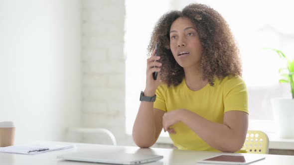 African Woman Talking on Phone at Work