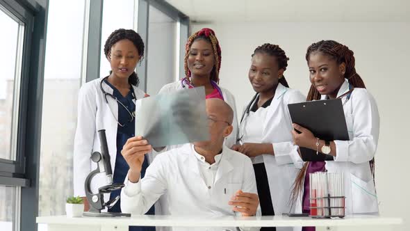 A Group of Four African American Students Discuss an Xray with the Doctor