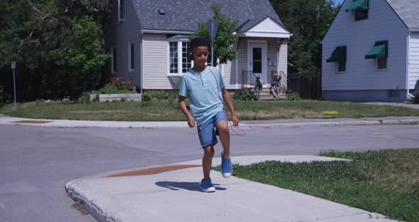 Young boy dancing while listening to headphones on the street