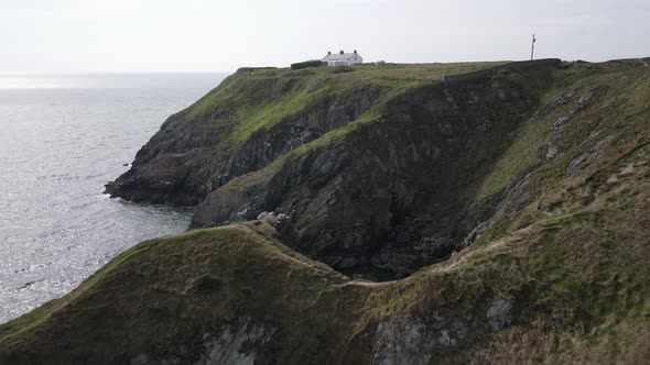 Bailey Cottage On Top Of Coastal Cliff In Howth, Dublin, Ireland. aerial drone