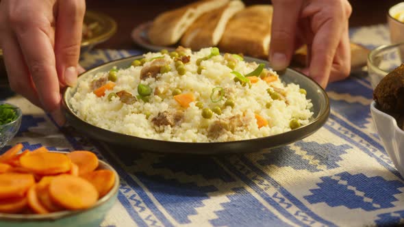 Putting Cooked Couscous with Chicken on Table Closeup