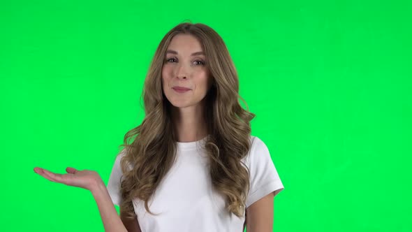 Lovable Girl Talking and Pointing Side Hand for Something, Copy Space. Green Screen